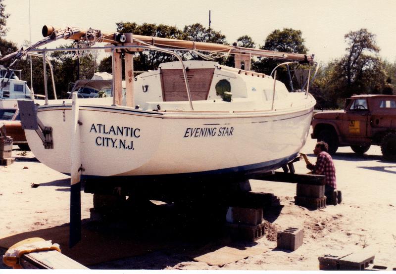 EveningStarOday23_005.jpg - Evening Star, our 1974 O-Day 23 sailboat in Chestnut Neck Boat yard, 1981.  Ken working on painting the water line.